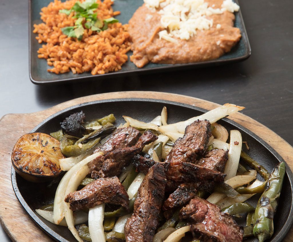 Fajitas at Barrios come with grilled onions and poblanos.