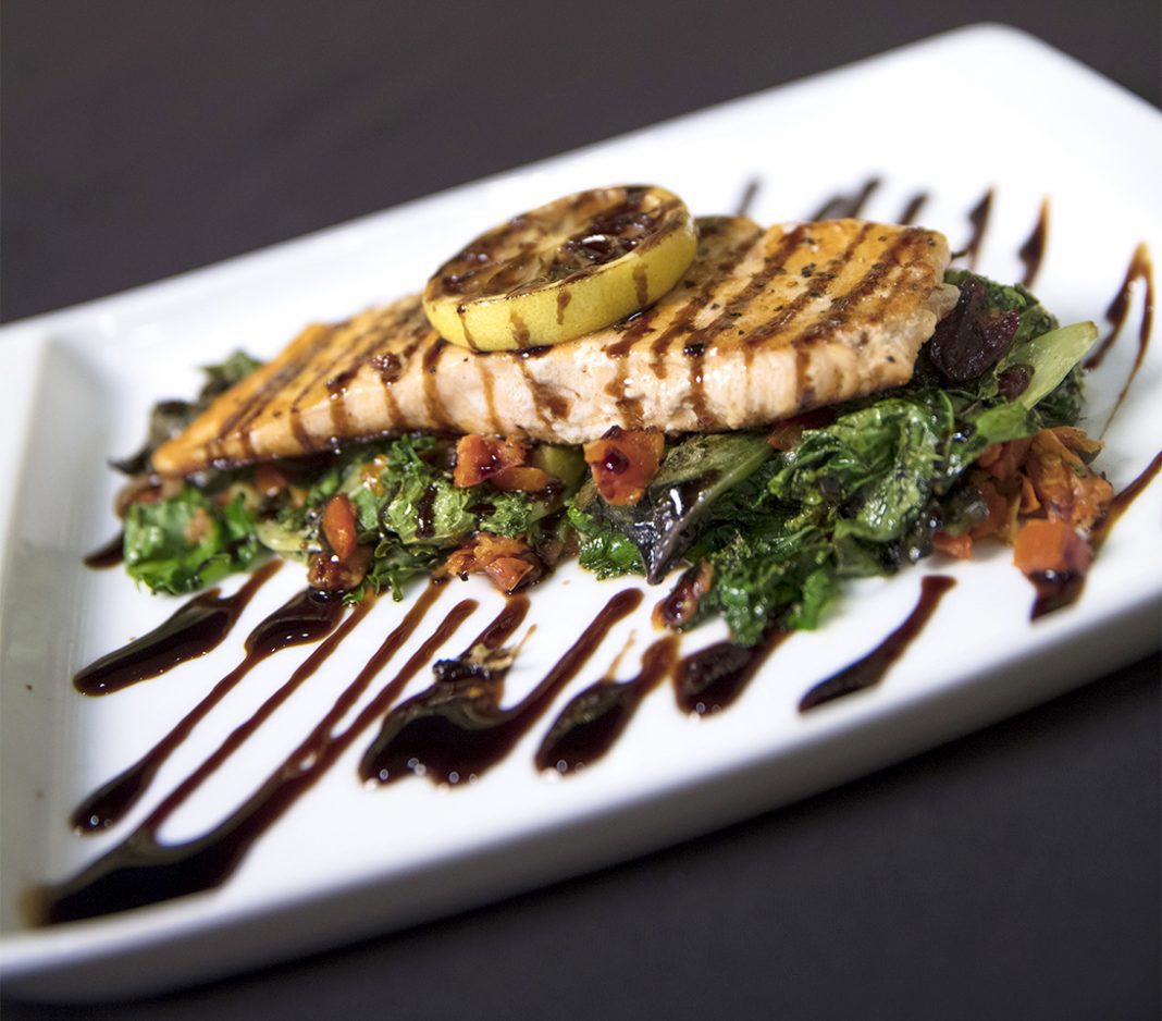 The grilled salmon is served over a bed of greens and glazed with balsamic.