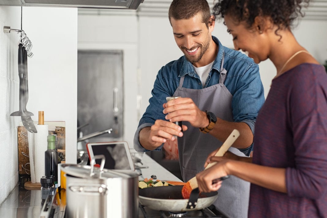 Man adding pepper in tomato sauce